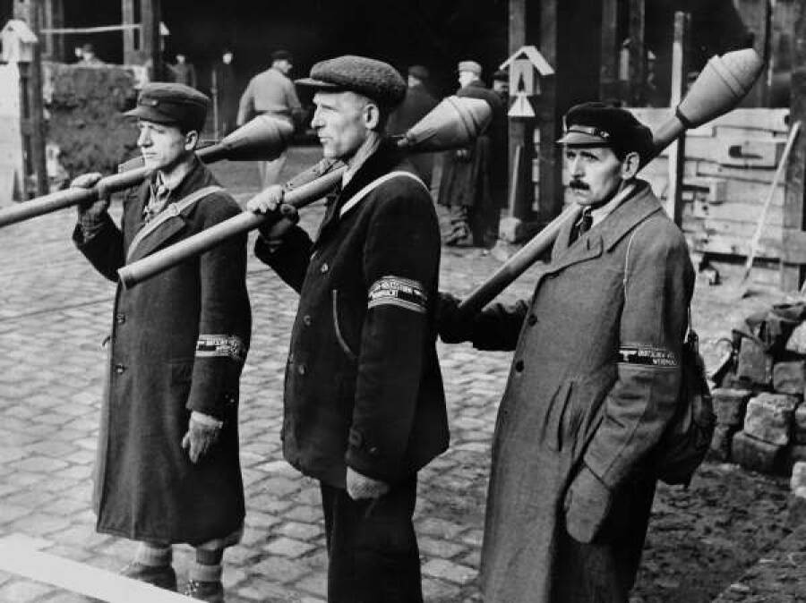 Вооруженные фаустпатронами фольксштурмовцы на улице Берлина, апрель 1945 года