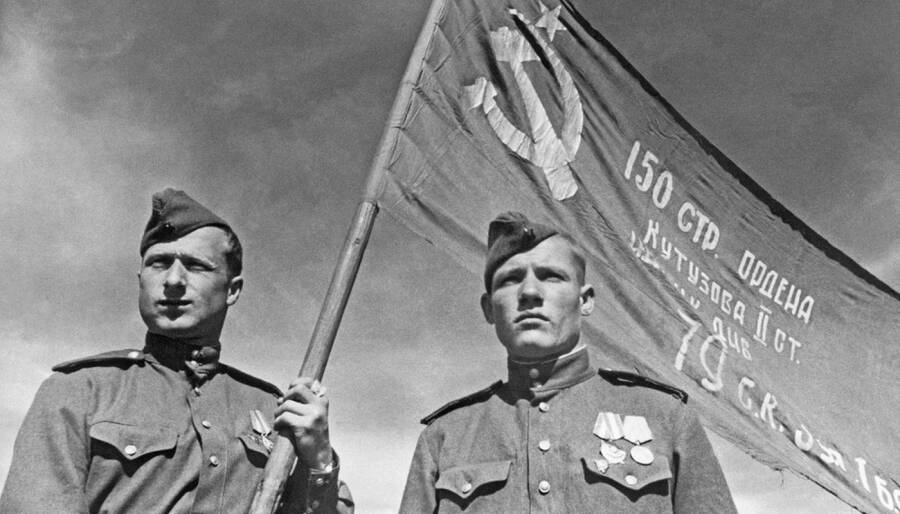 Младший сержант Мелитон Кантария (слева) и сержант Михаил Егоров (справа) со Знаменем Победы, водруженным 1 мая 1945 года над зданием рейхстага в Берлине