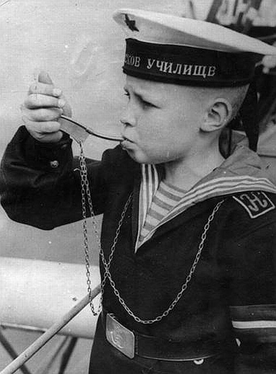 Дневальный, воспитанник нахимовского училища, подает сигнал с помощью боцманской дудки, 1940-е