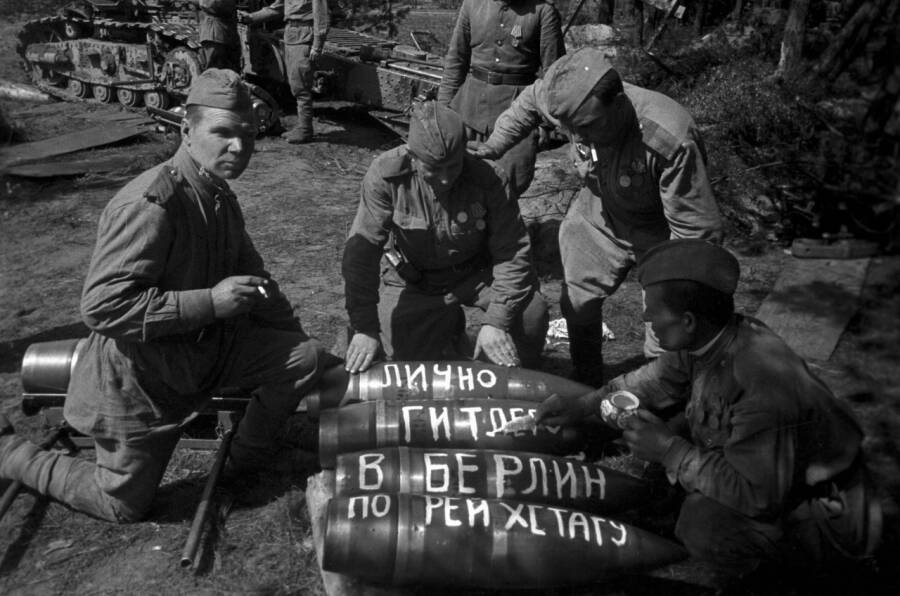 Советские артиллеристы из расчета тяжелой 203-мм гаубицы Б-4 делают надписи на снарядах перед началом битвы за Берлин, апрель 1945 года