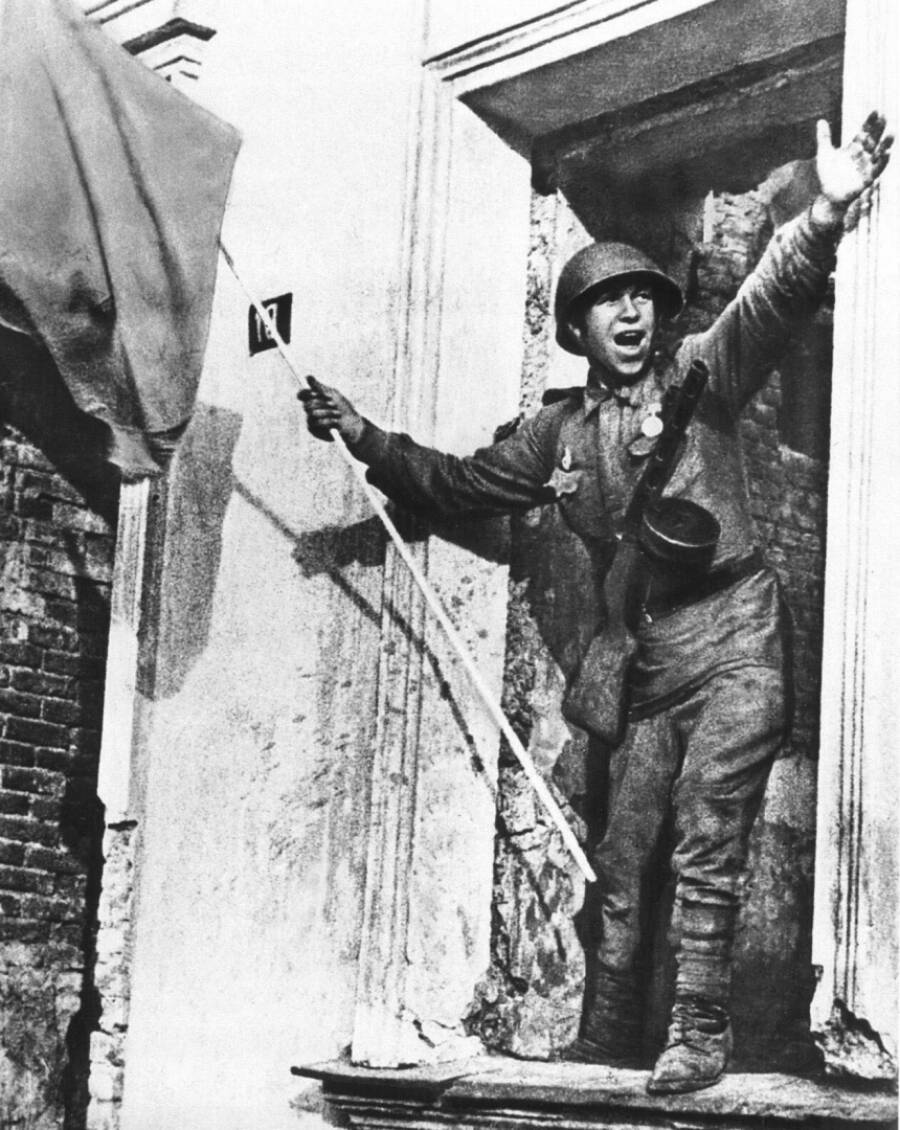 Советский солдат со знаменем в освобожденном Орле