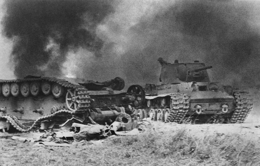Советский тяжелый танк КВ-1 проезжает мимо подбитого немецкого танка Pz.Kpfw. IV, Курская дуга, июль-август 1943 года