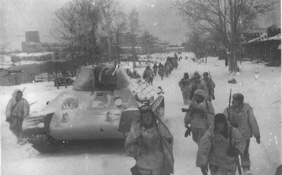 Советские войска на марше. Контрнаступление советских войск под Москвой. На танк нанесен зимний камуфляж, все бойцы в маскхалатах