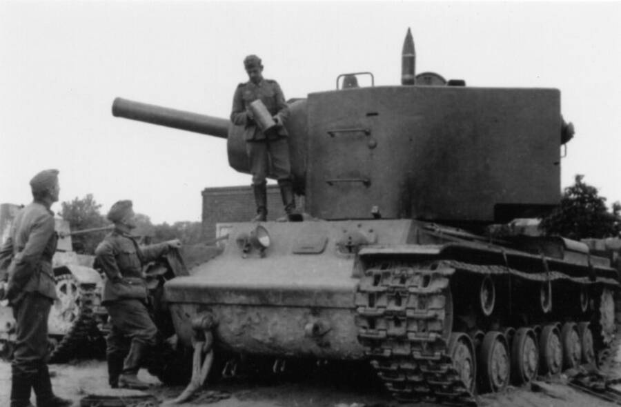 Немецкие солдаты изучают брошенный советский танк КВ-2. Хорошо виден снаряд и гильза