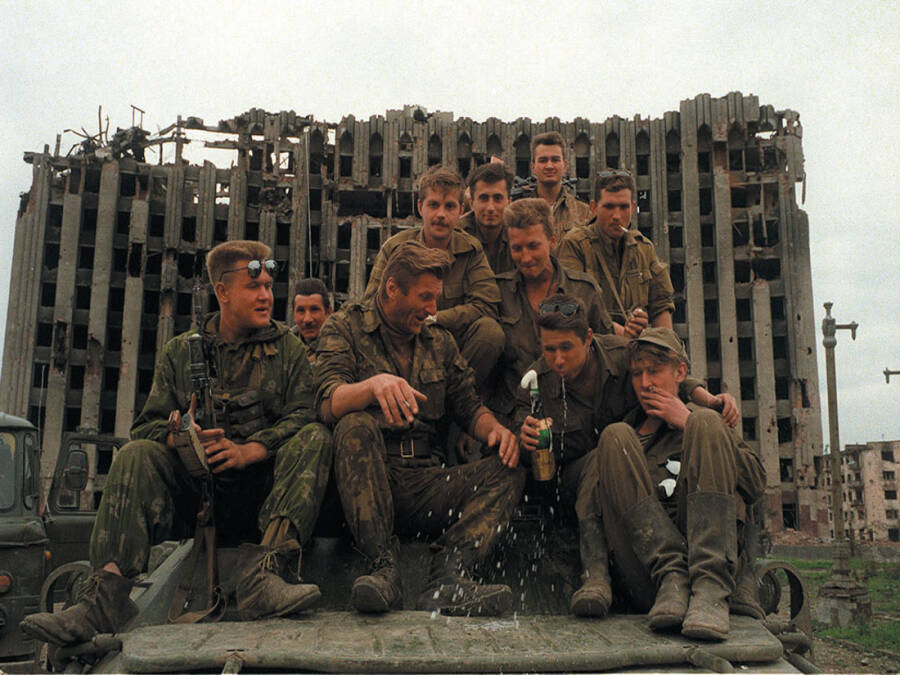 Russian soldiers against the backdrop of the destroyed presidential palace in Grozny, 1995. 