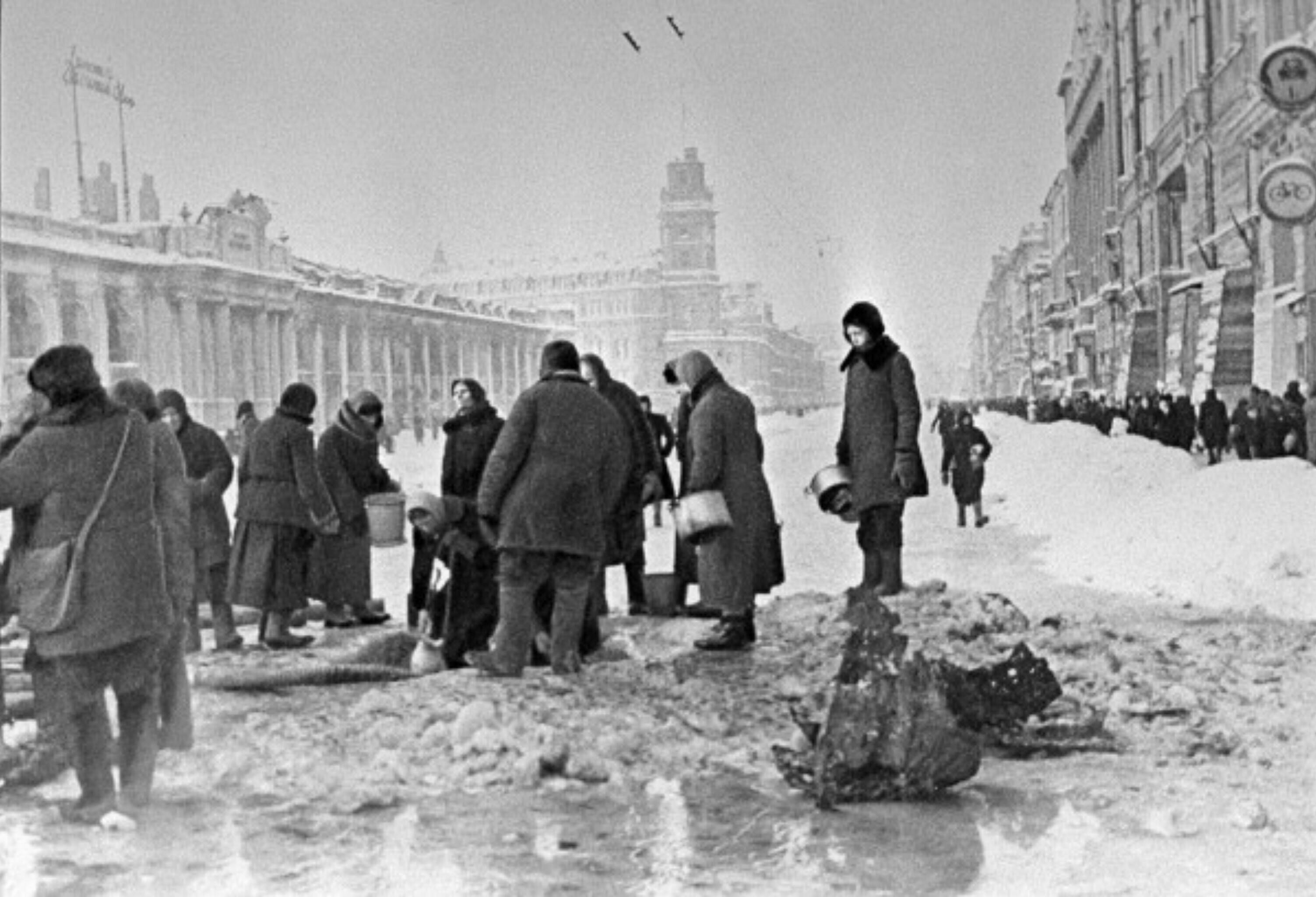  Жители блокадного Ленинграда набирают воду, появившуюся после артобстрела в пробоинах в асфальте на Невском проспекте (RIA Novosti archive, image #907 / Boris Kudoyarov / CC-BY-SA 3.0)