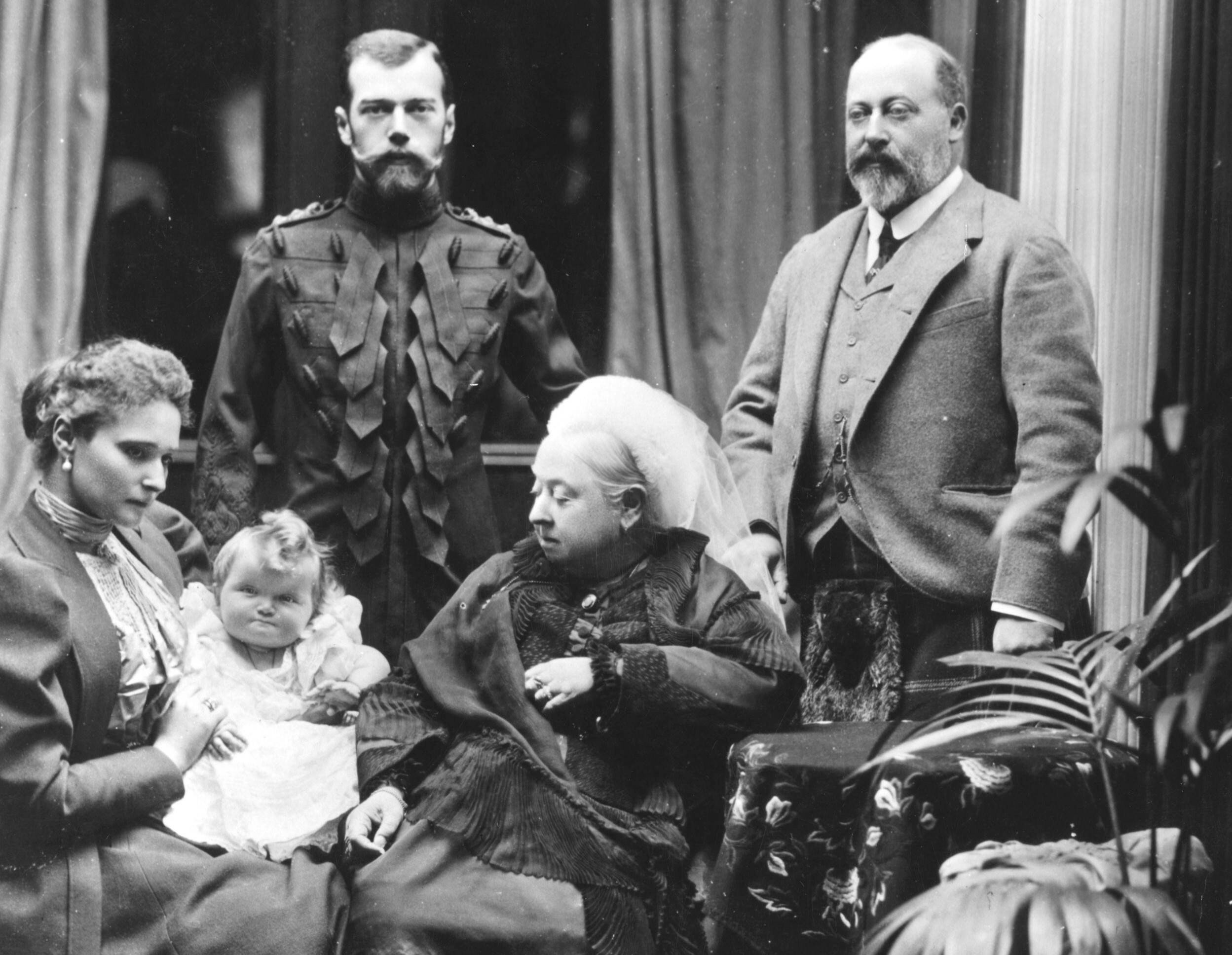 Королева Великобритании Виктория со своим сыном Эдвардом, принцем Уэльским (справа), и российским царём Николаем II (слева). Сидит царица Александра Фёдоровна, держа на руках свою маленькую дочь великую княгиню Ольгу.
