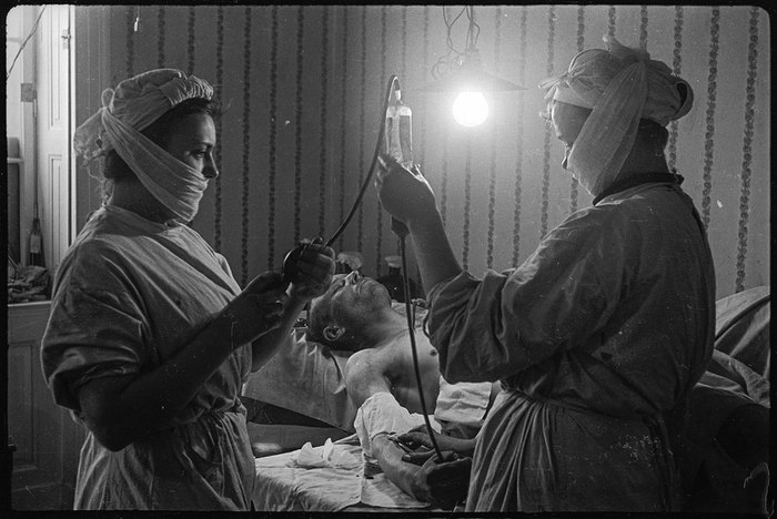 Медсестры готовят раненного к переливанию крови в полевом подвижном госпитале