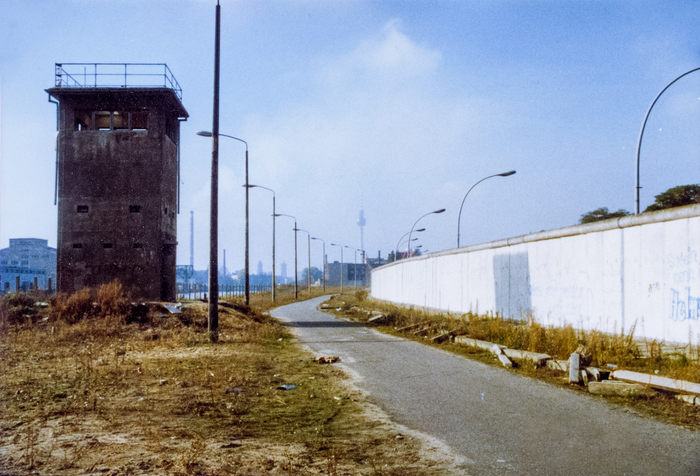 Так называемая «полоса смерти» Берлинской стены. Хорошо виден последний рубеж ограждения — бетонный забор на границе с Западным Берлином, по верху которого идет закругленный бордюр, не позволяющий зацепиться, и дорожка для патрулирования перед ним
