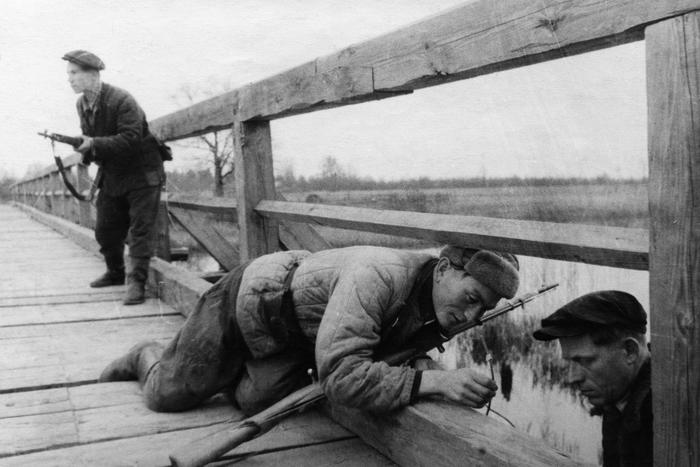 Партизаны отряда имени Ворошилова готовят подрыв деревянного моста над рекой, 1943 год