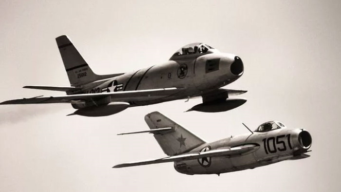 Реактивные истребители F-86 «Сейбр» и МиГ-15 в парном полете (современный снимок). Окраска американского самолета соответствует опознавательным знакам позднего этапа Корейской войны; МиГ-15 имеет опознавательные знаки северокорейских ВВС
