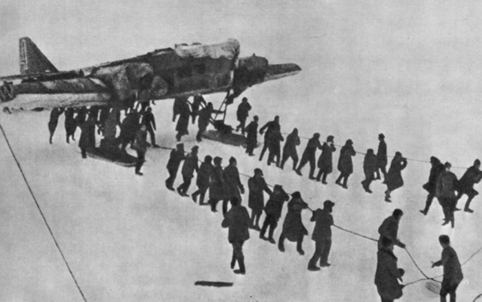 Челюскинцы тянут самолет АНТ-4 Анатолия Ляпидевского к месту старта с ледяного аэродрома, Чукотское море, апрель 1934 года